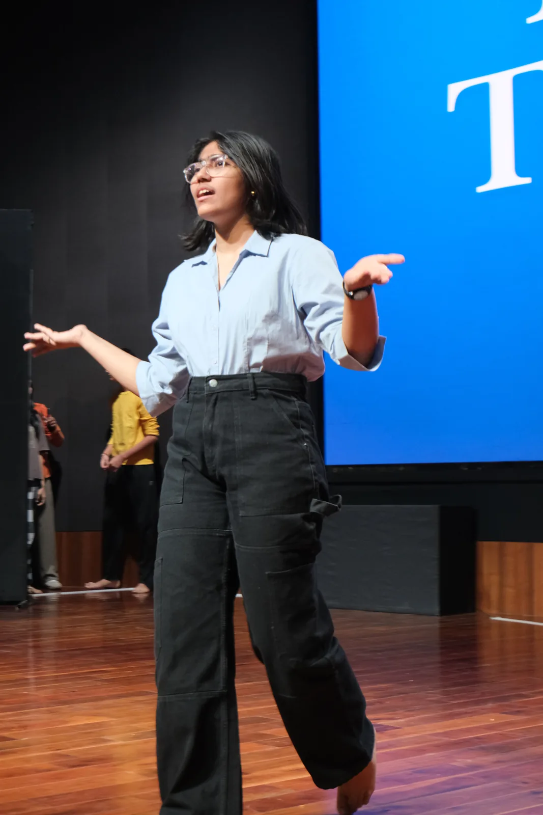 A young climate speaker presenting an idea on stage