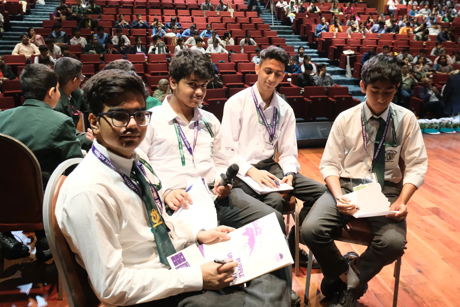 Young climate speakers preparing ideas together on stage